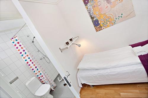 特隆赫姆Sandmoen Bed & Breakfast, Free Parking的一间带一张床和淋浴的小卧室