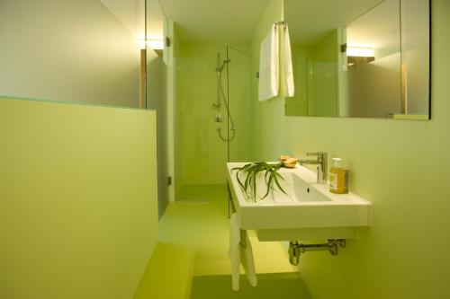 多恩比恩Hotel Alpenrose Ebnit的绿色浴室设有水槽和镜子