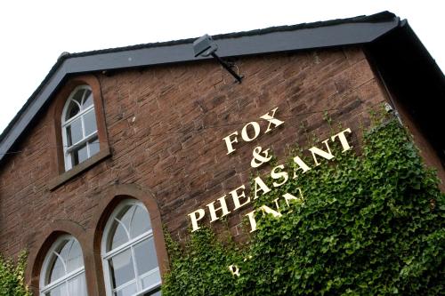 ArmathwaiteFox and Pheasant Inn的砖楼边的标志