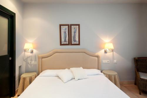 纳瓦拉维拉伯迪公寓式酒店及套房的卧室配有白色的床和2个枕头