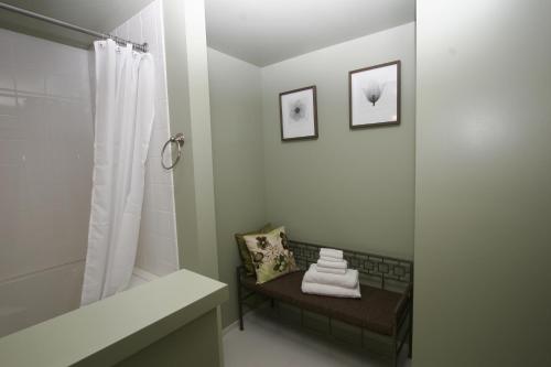 奥克港Wildwood Farm Bed & Breakfast的浴室配有淋浴和带毛巾的长凳
