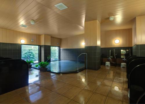 Ōfunato鲁特奥范纳图酒店的大型客房,位于大楼内,设有玻璃淋浴间