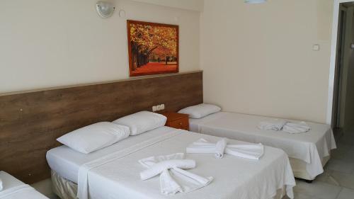 库萨达斯奥兹根公寓式酒店的一间设有两张床的房间,上面有白色的毛巾