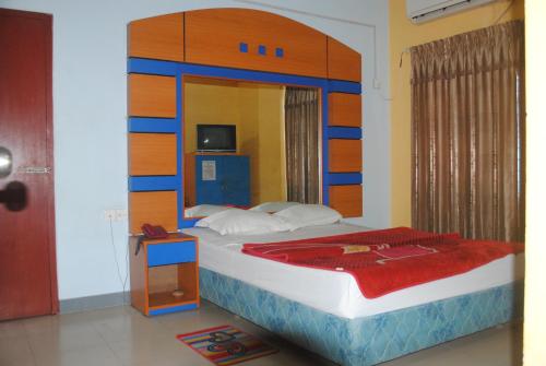 库克斯巴扎Hotel Sea Alif的一间卧室配有一张大床和木制床头板