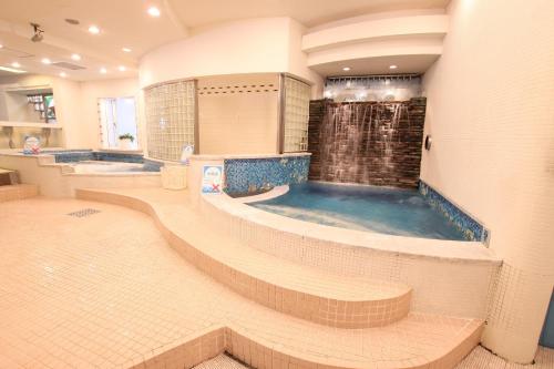 大阪大阪胶囊旅馆（仅限男性）的大型浴室设有带淋浴的浴缸。