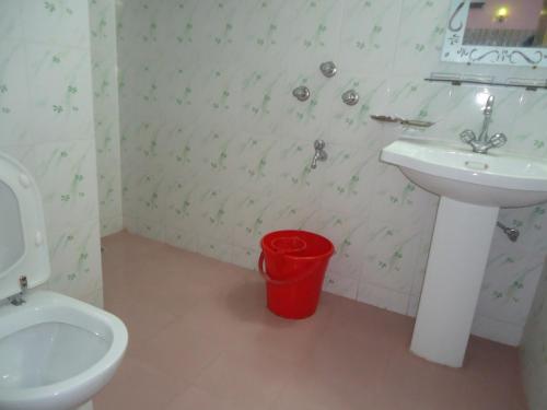库克斯巴扎Unity Inn的一间带水槽、卫生间和水桶的浴室