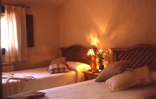 比利亚尔瓦德拉谢拉尼丽亚乡村旅馆的一间卧室设有两张床和一张桌子上的台灯。