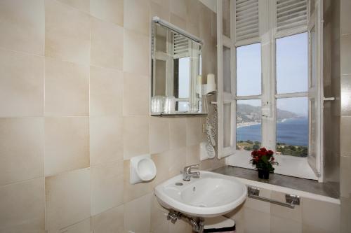 陶尔米纳阿斯托利亚别墅酒店的一间带水槽和窗户的浴室