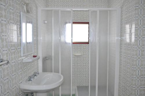 拉雷斯廷加雷斯廷加公寓的白色的浴室设有水槽和淋浴。