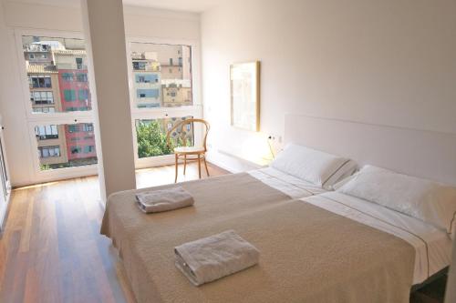 赫罗纳Flateli Canalejas的一间卧室配有一张大床和两条毛巾