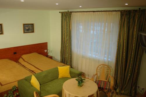 赛比什桦树乡村俱乐部酒店的一间卧室配有绿色的沙发和一张床