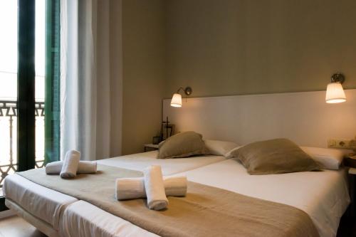 巴塞罗那宝拉木西卡公寓的一间卧室配有两张带毛巾的床
