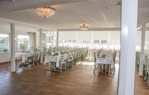 GrundsundRågårdsvik的宴会厅配有白色的桌椅和窗户