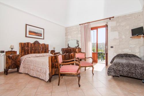 莫迪卡吉雅蒂尼曼德里尼住宿加早餐旅馆的一间卧室配有一张床、椅子和电视