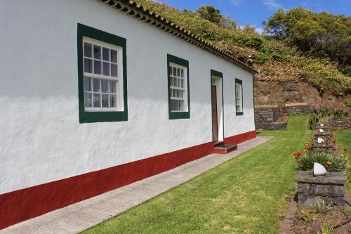 Santo EspíritoCasa da Avó - Turismo Rural的白色的房子,设有绿色的窗户和庭院