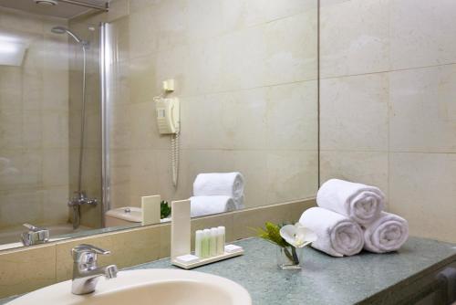 安道尔城Sercotel Delfos Andorra的浴室配有盥洗盆、镜子和毛巾