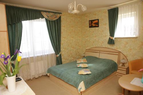 阿利图斯Guest House Linas的一间卧室配有一张带绿色床单和窗帘的床