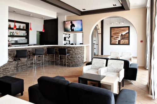 提诺斯波塞冬尼奥酒店的一间酒吧,位于一个配有沙发和椅子的房间