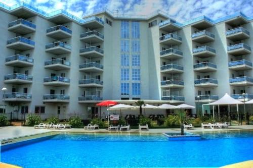 锡尔维玛丽娜埃琳娜俱乐部度假酒店的大型酒店前方设有游泳池