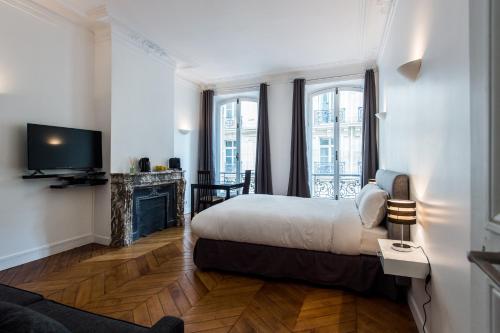 巴黎Paris Square的酒店客房配有一张床和一个壁炉。