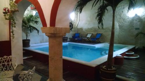 坎佩切玛雅阿金佩赫酒店的棕榈树房子里的游泳池