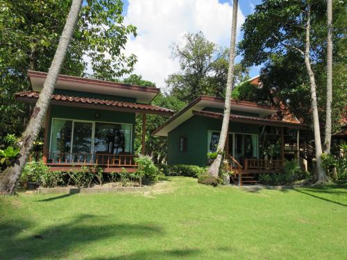 象岛邦宝滩度假酒店的前面有树木的绿色房子