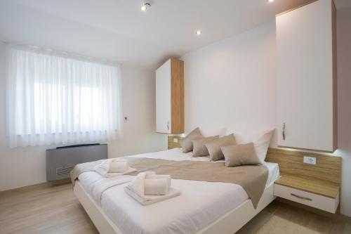 普拉阿德里翁公寓式酒店的白色卧室配有一张带白色枕头的大床