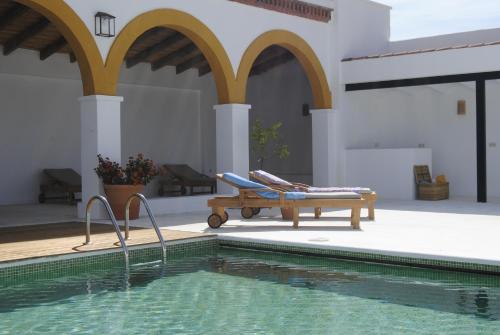 列雷纳科尔蒂霍德维加格兰德酒店的房屋旁带长凳的游泳池