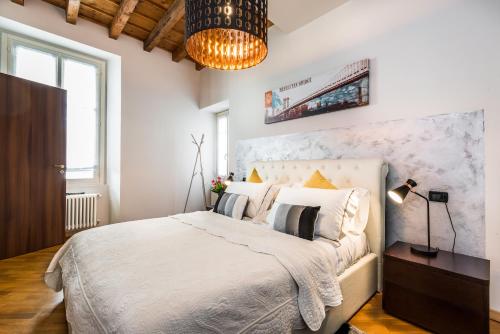 科莫丽雷斯迪吉达公寓的一间卧室配有一张大床和一个吊灯。
