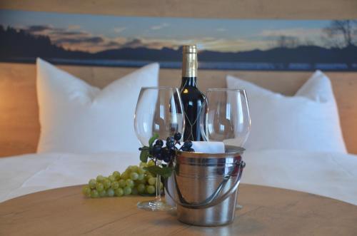 基姆湖畔贝尔瑙Hotel Seiserhof & Seiseralm的桌子上放一瓶葡萄酒和酒杯