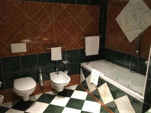 斯特雷萨蕾佳娜皇宫酒店的浴室配有卫生间、浴缸和水槽。