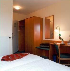 迪斯考ARC酒店的酒店客房配有一张床、一张书桌和一张书桌。