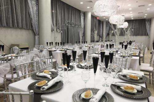 布鲁克林特广场酒店的宴会厅配有白色的桌椅和吊灯