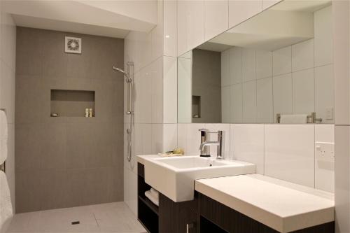 拉塞尔科科莫公寓的白色的浴室设有水槽和淋浴。