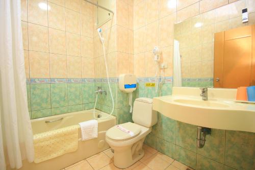 罗东镇东方商务大饭店的浴室配有卫生间、盥洗盆和浴缸。