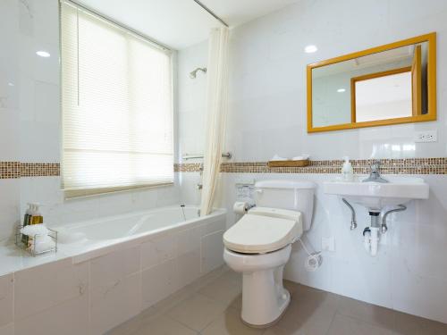 科罗尔科罗尔中心花园皇宫酒店的浴室配有卫生间、浴缸和水槽。