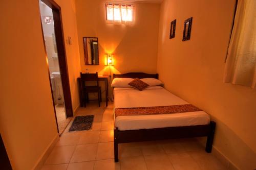 日惹安德烈住宿加早餐旅馆的一间小卧室,房间内设有两张床