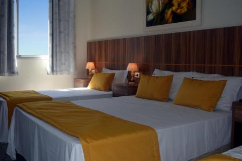 里约热内卢外交家科帕卡瓦纳酒店的酒店客房 - 带两张带黄色枕头的床