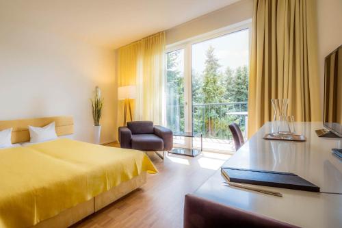 多森海姆米多里 - 绿色宾馆的酒店客房配有一张黄色的床和一张书桌