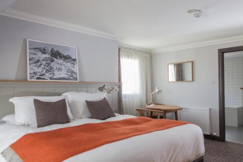 波特里博斯维勒酒店的一间卧室配有一张带橙色毯子的大床