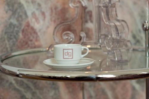莱切德吉奥吉宫殿住宿加早餐旅馆的玻璃桌上的咖啡杯和碟子