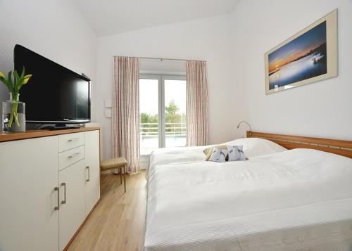朱列斯拉赫Ferienwohnung Strandkorb的一间卧室配有一张床和一台平面电视