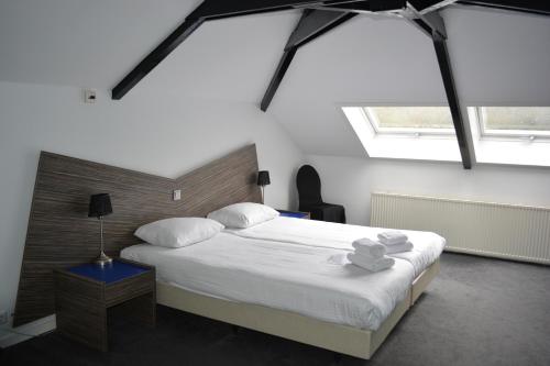 阿珀尔多伦Hotel Oranjeoord的卧室配有一张带白色床单和枕头的大床。