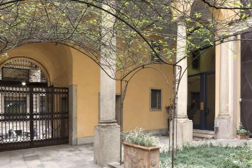 米兰numa l Camperio Rooms & Apartments的进入有黑色门的建筑物的入口