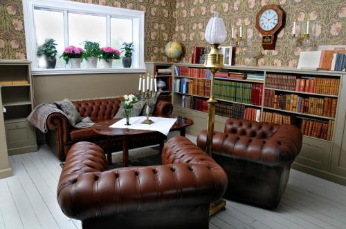 Gemla格兰霍尔姆别墅酒店的客厅配有两张真皮座椅和一张桌子