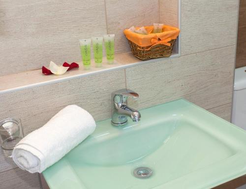 帕尔加Oasis Exclusive的浴室水槽,架子上装有毛巾和玻璃杯