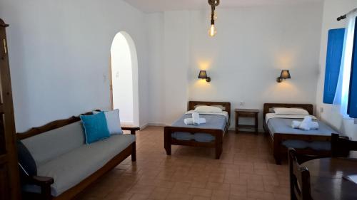 伊亚莱奥卡斯缇别墅酒店的客房设有两张床、一张沙发和一张桌子。