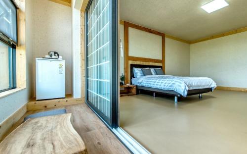 西归浦市巴达丸度假屋的一间卧室配有一张床和一个小冰箱