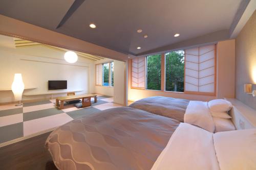 草津草津斯凯兰酒店的一间带大床和电视的卧室