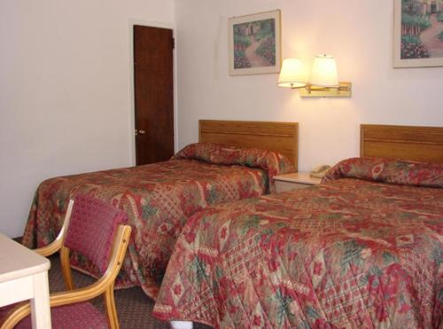 Morgantown摩根镇红地毯旅店&套房酒店的酒店客房设有两张床和一张桌子。